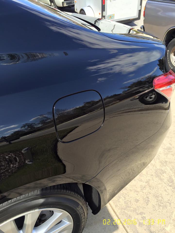 A black car is parked on the side of the road.