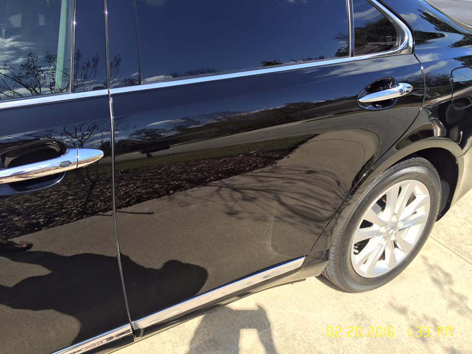 A black car is parked on the side of the road