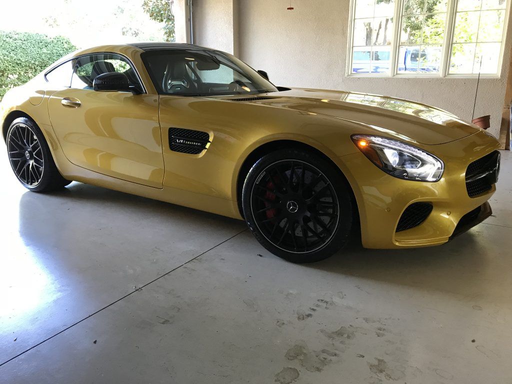 A yellow sports car is parked in a garage.