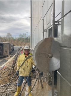 A person standing next to a large circular saw