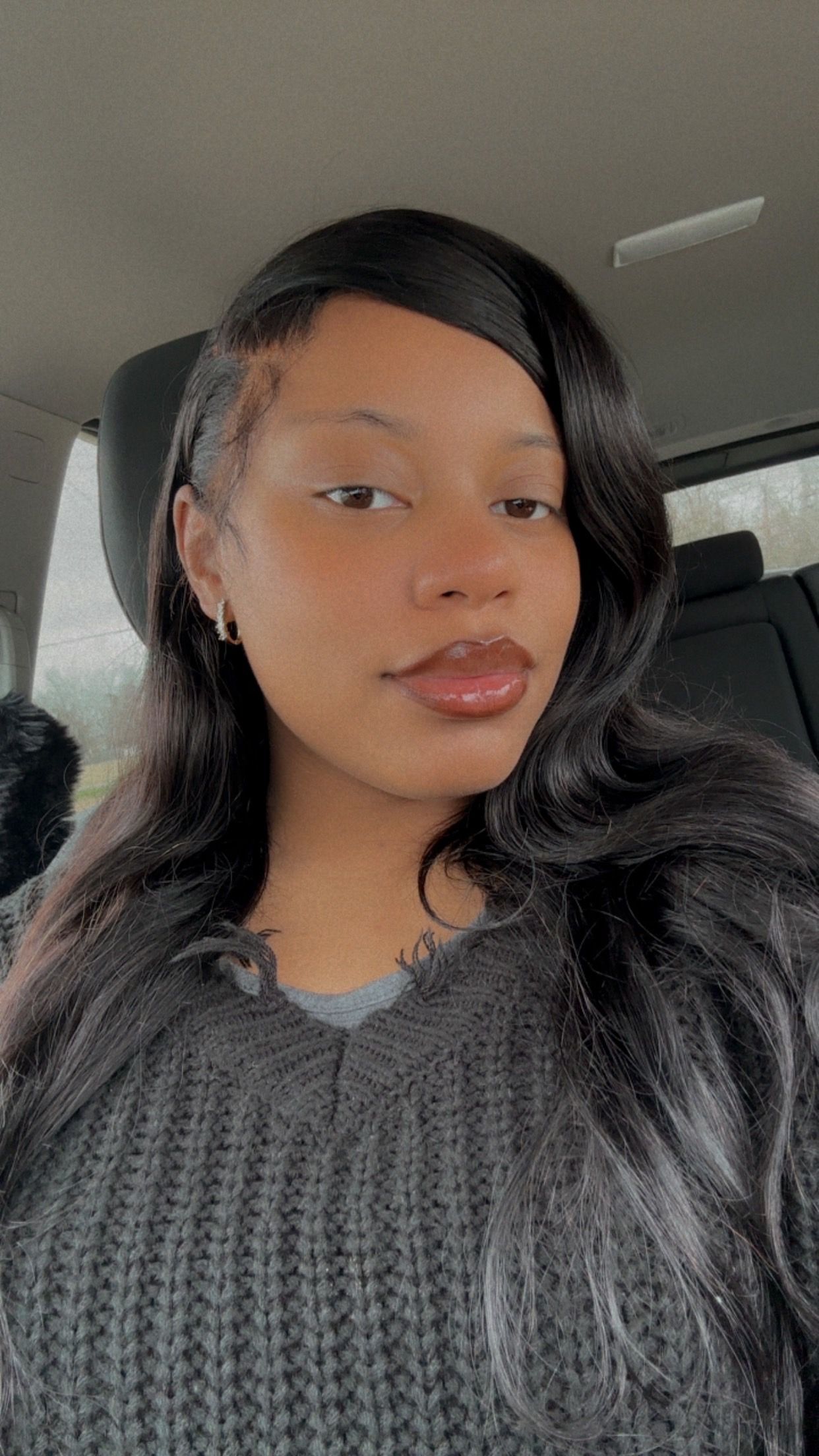 Woman in a gray sweater and dark hair looks at the camera.