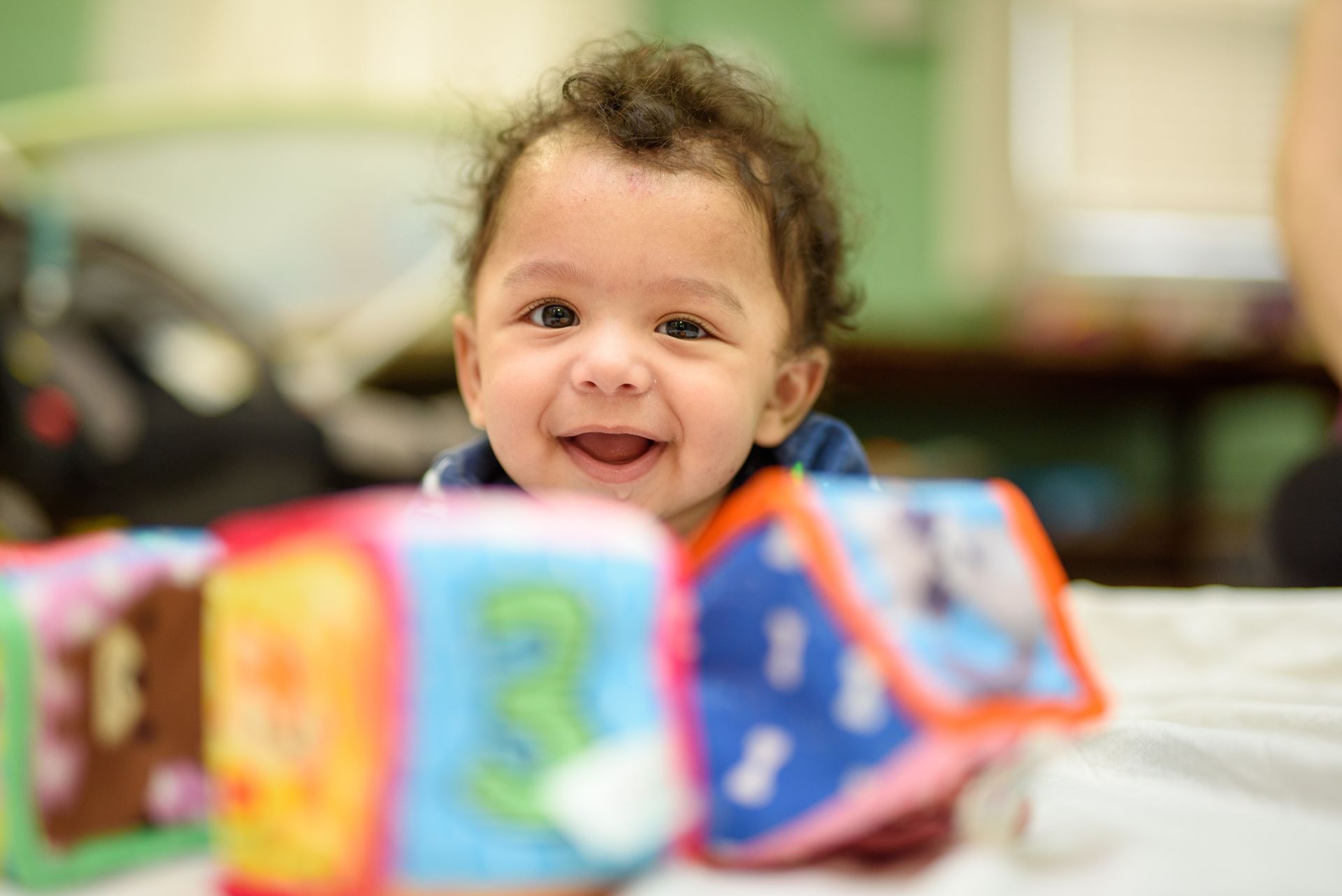A baby is laying on a blanket in a bouncer.