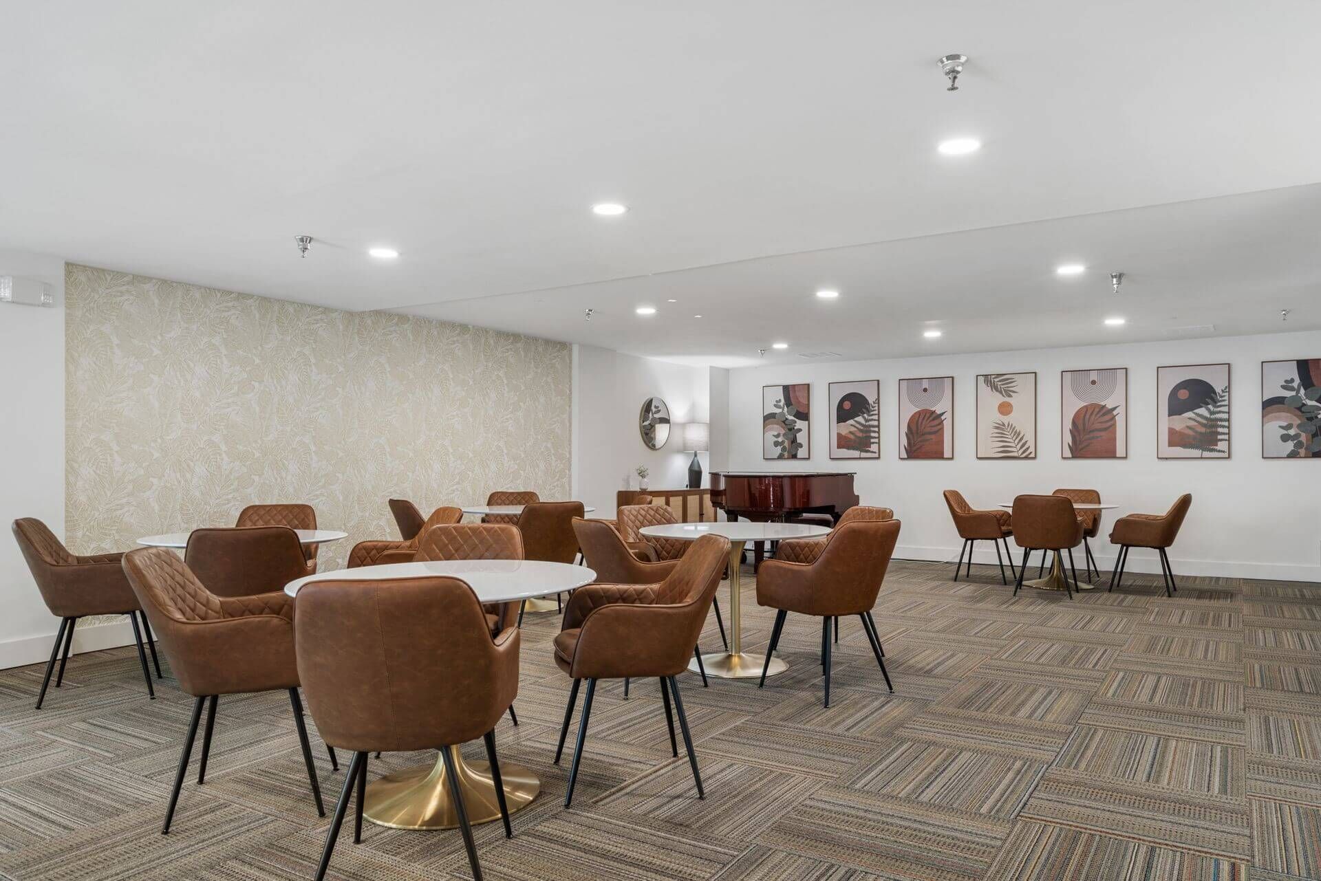 Spacious dining room with paintings on the walls at Clairmont Crest senior living apartments in Decatur, GA.