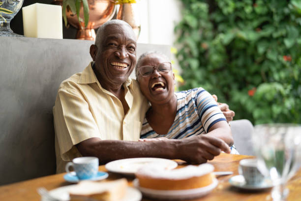 An elderly couple is sitting at a table with plates of food.