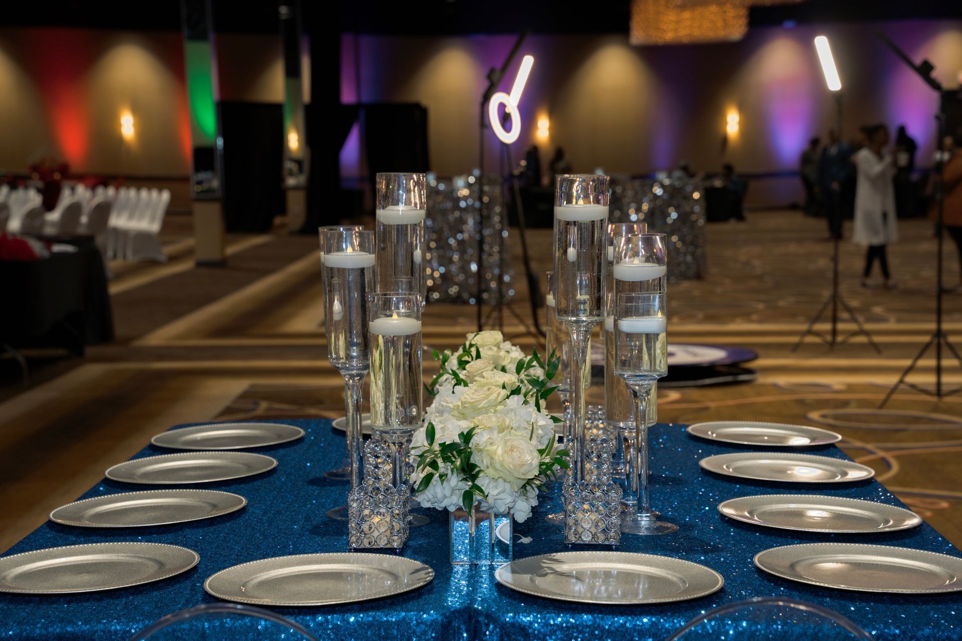 A table set for a wedding reception with plates and candles on it.