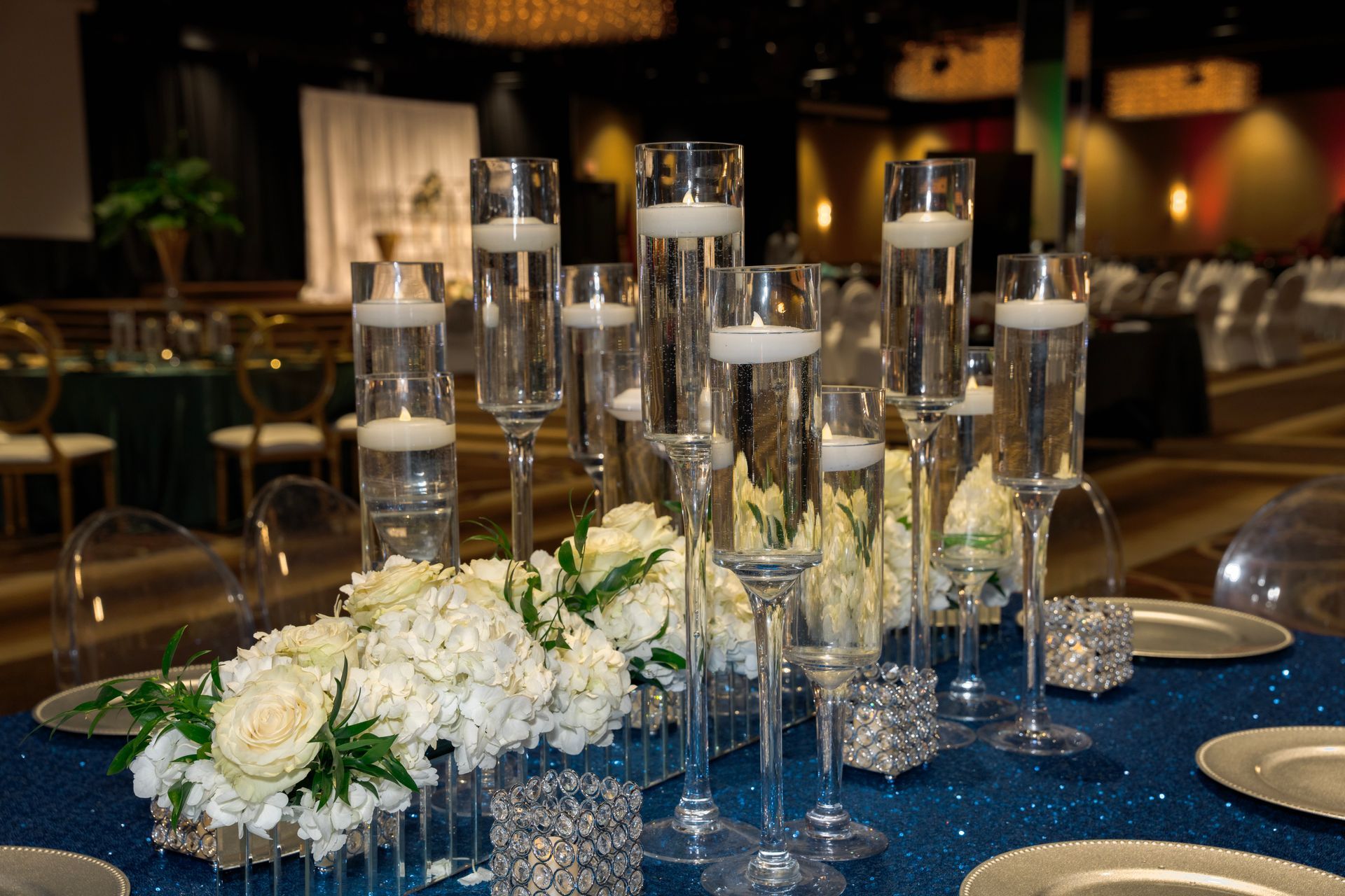 A table set for a wedding reception with candles and flowers on it.