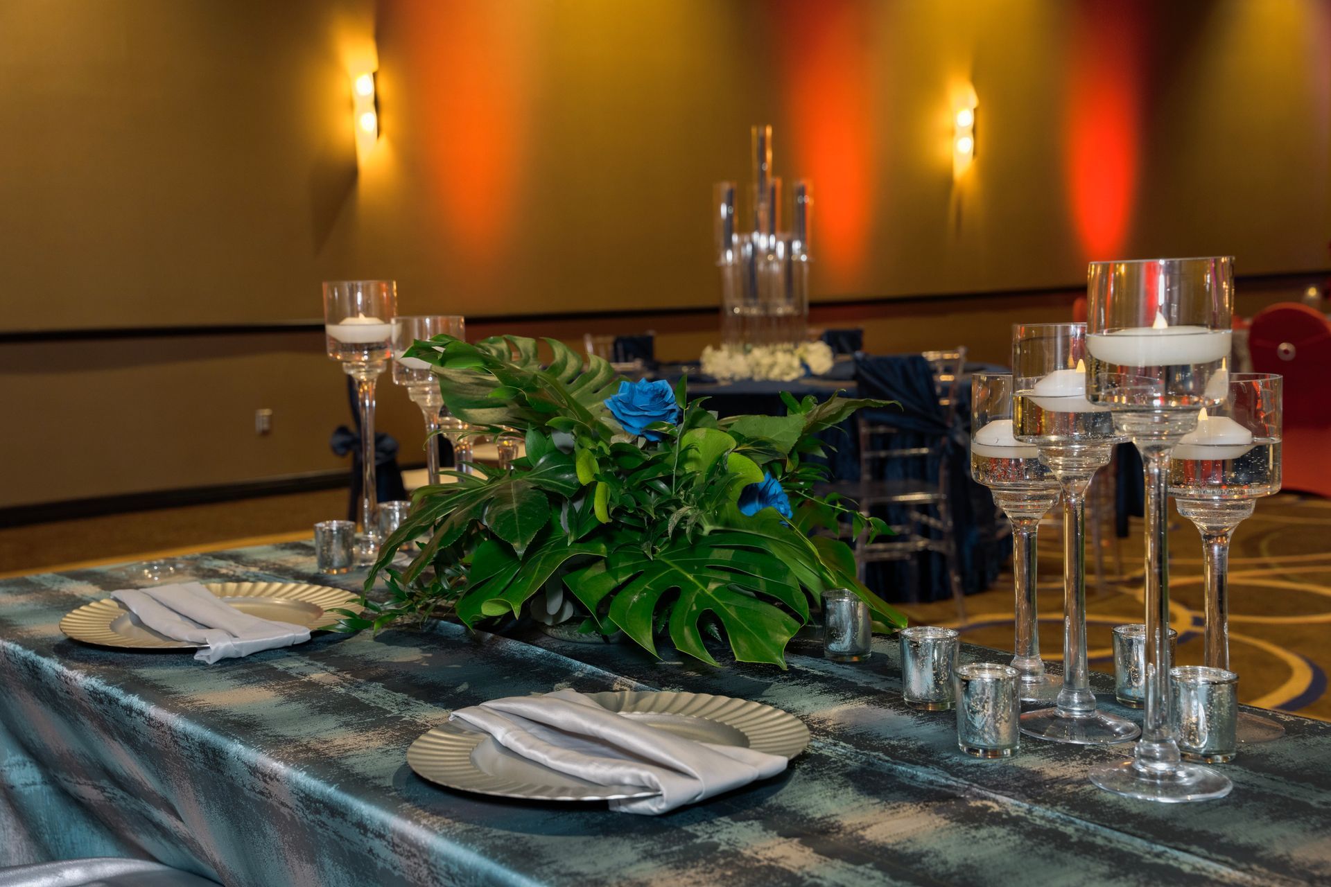A long table with plates , candles , and flowers on it.