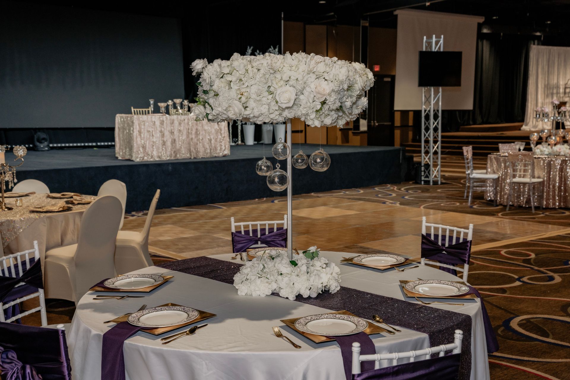 A large room with tables and chairs set up for a wedding reception.
