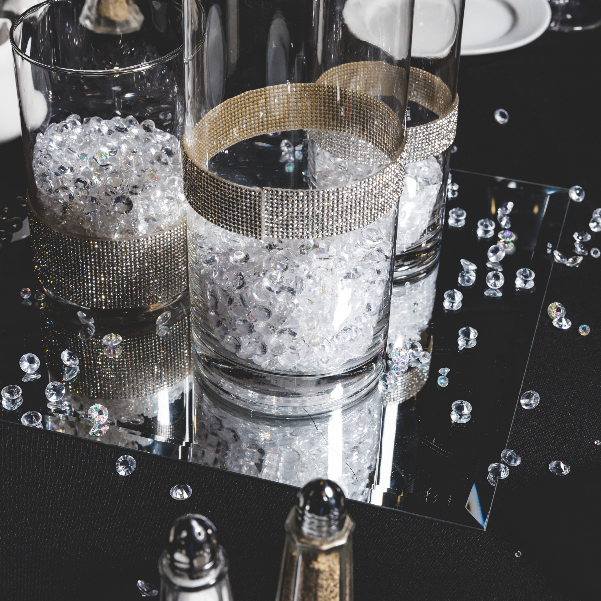 A salt and pepper shaker sits next to a vase filled with crystals