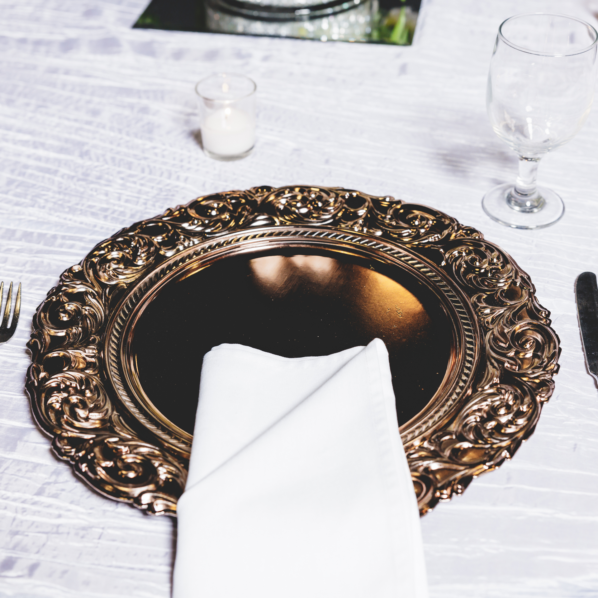 A place setting with a gold plate and a white napkin
