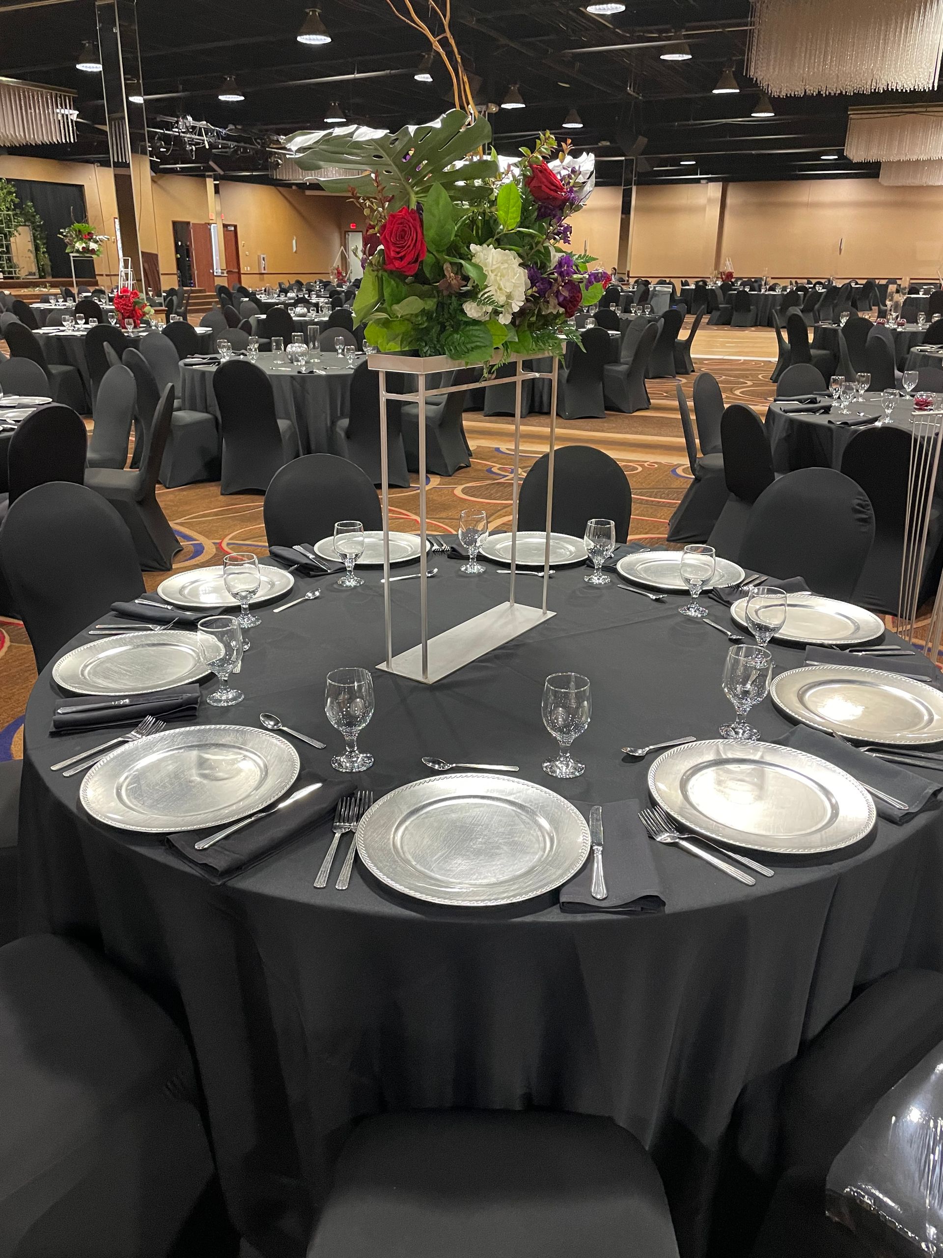 A large room with tables and chairs set up for a wedding reception