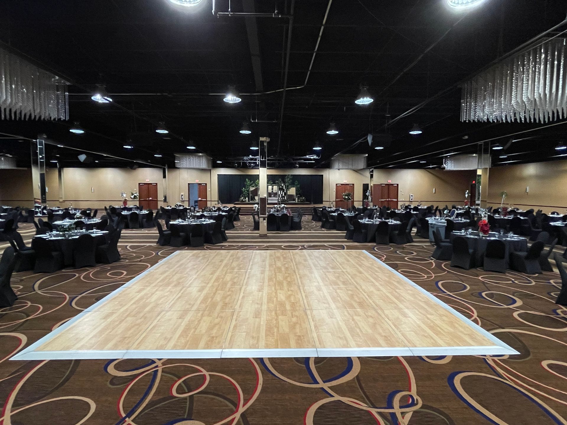 A large room with tables and chairs and a dance floor