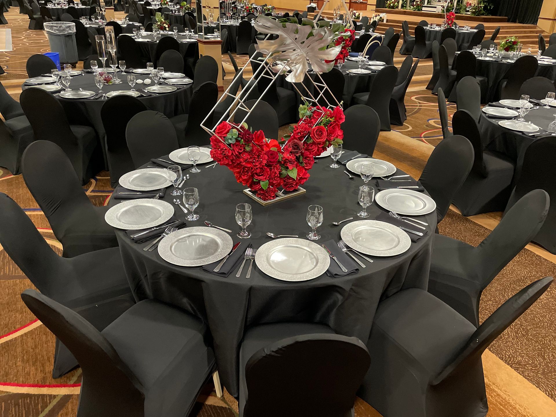 A large room with tables and chairs set up for a wedding reception.