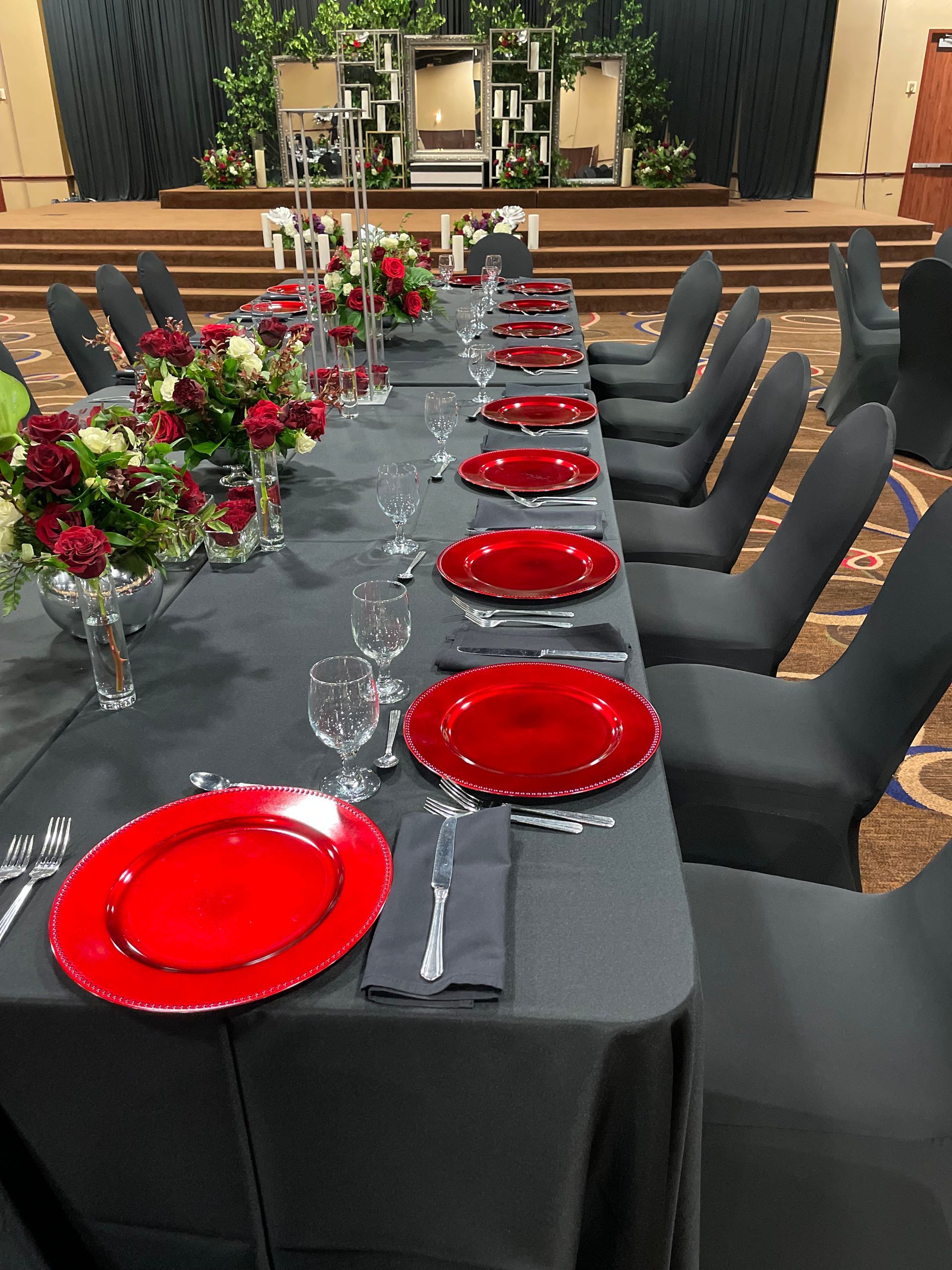 A long table with red plates and glasses on it