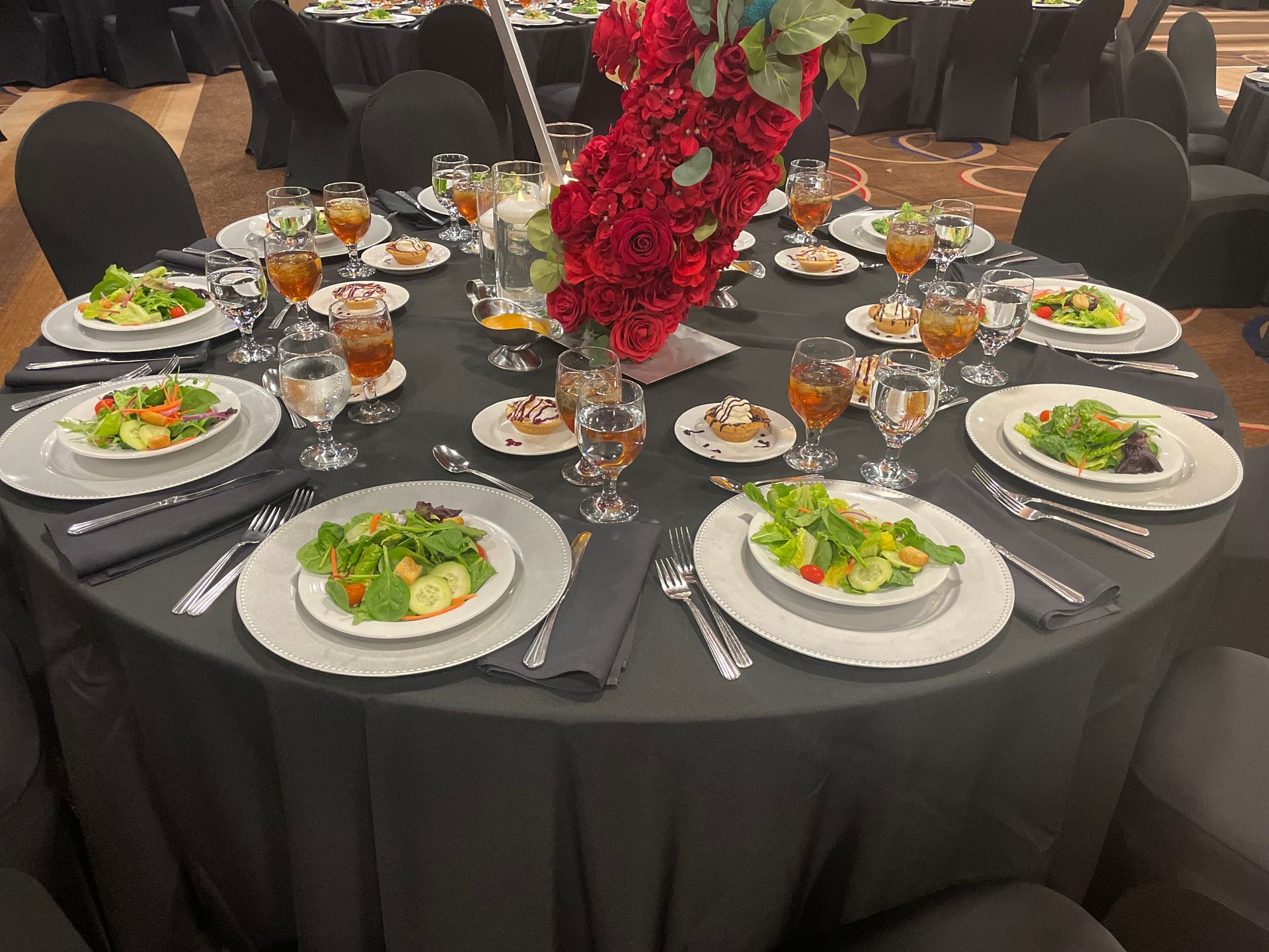A table set for a banquet with plates of food and wine glasses.