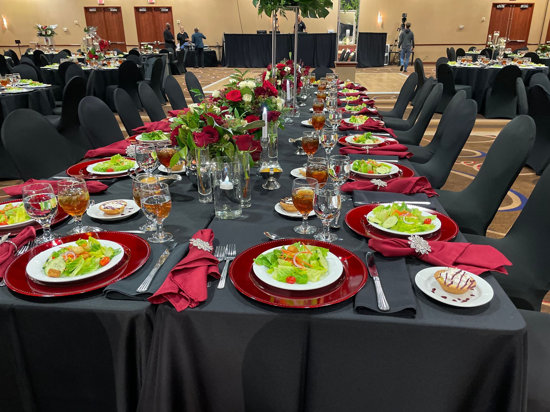 A long table with plates , wine glasses , and flowers on it.