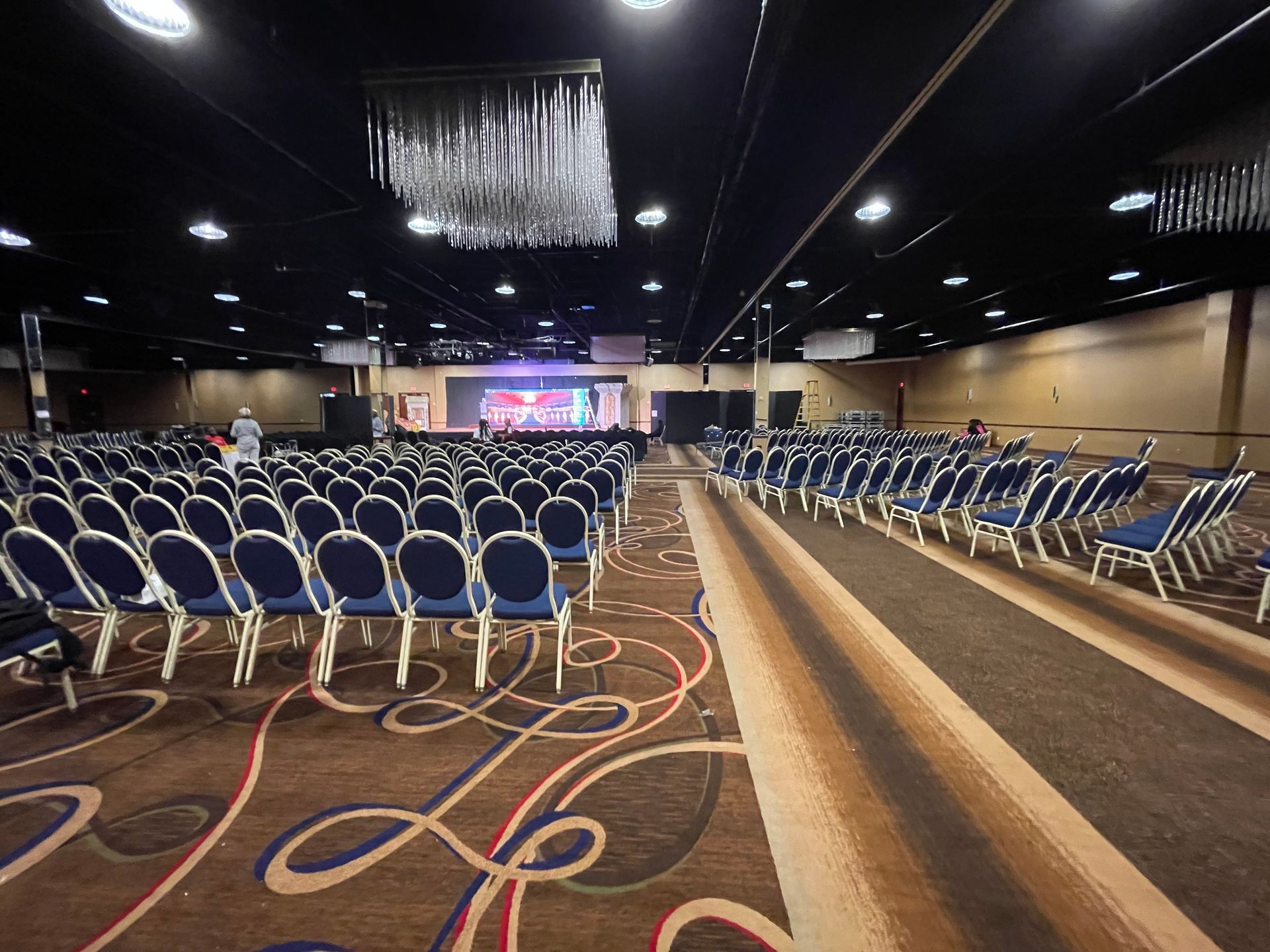 A large auditorium with rows of chairs and a stage.