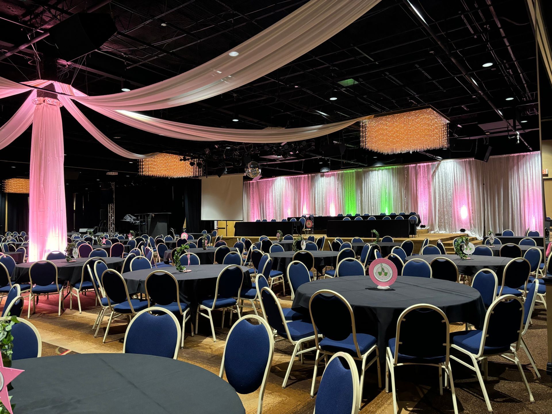 A large room with tables and chairs set up for a party