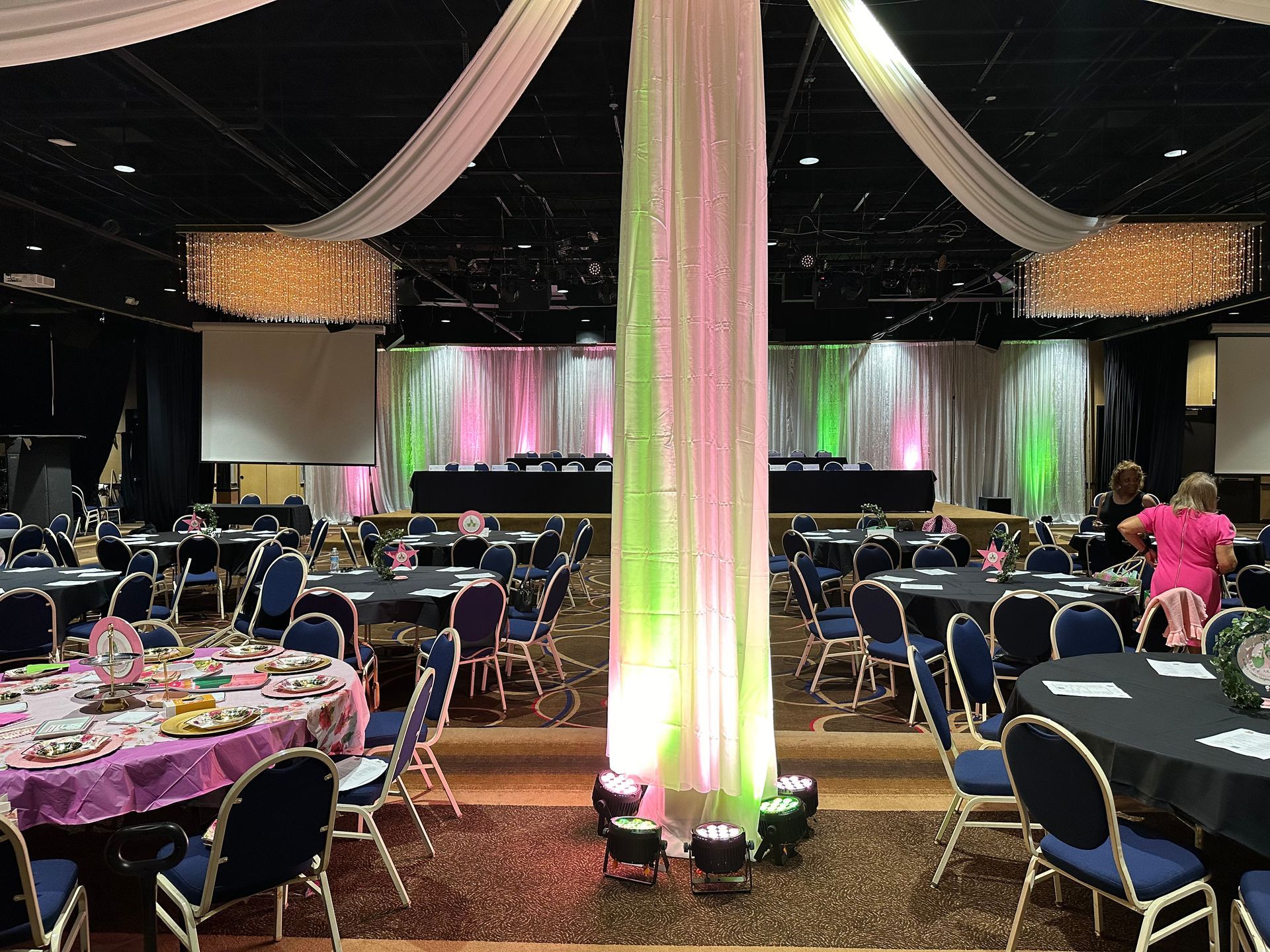 A large room with tables and chairs set up for a party.