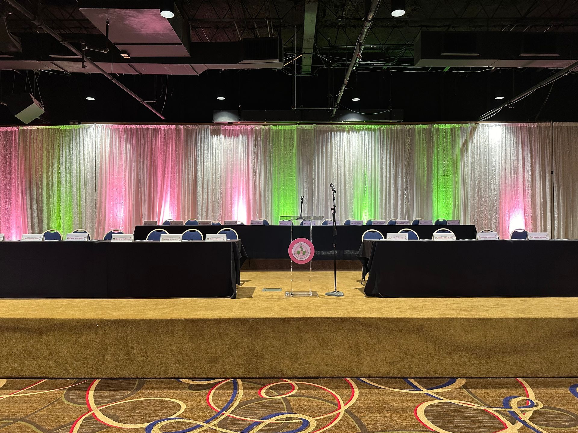 There is a stage in the middle of the room with tables and chairs.