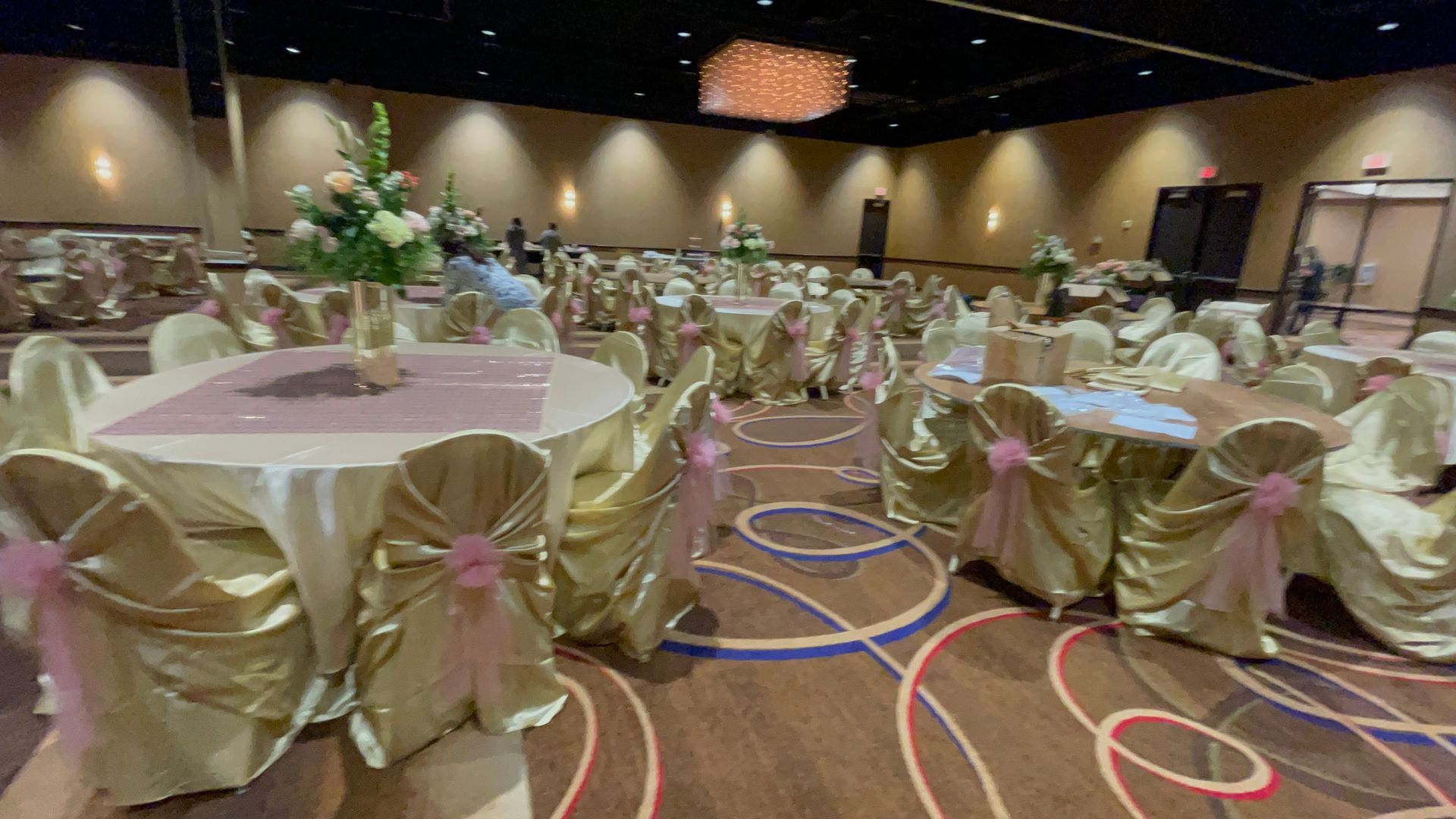 A large room with tables and chairs set up for a quinceañera.