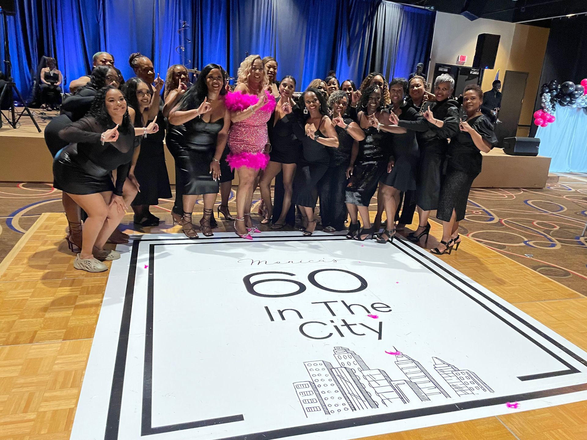 A group of women are posing for a picture on a dance floor.