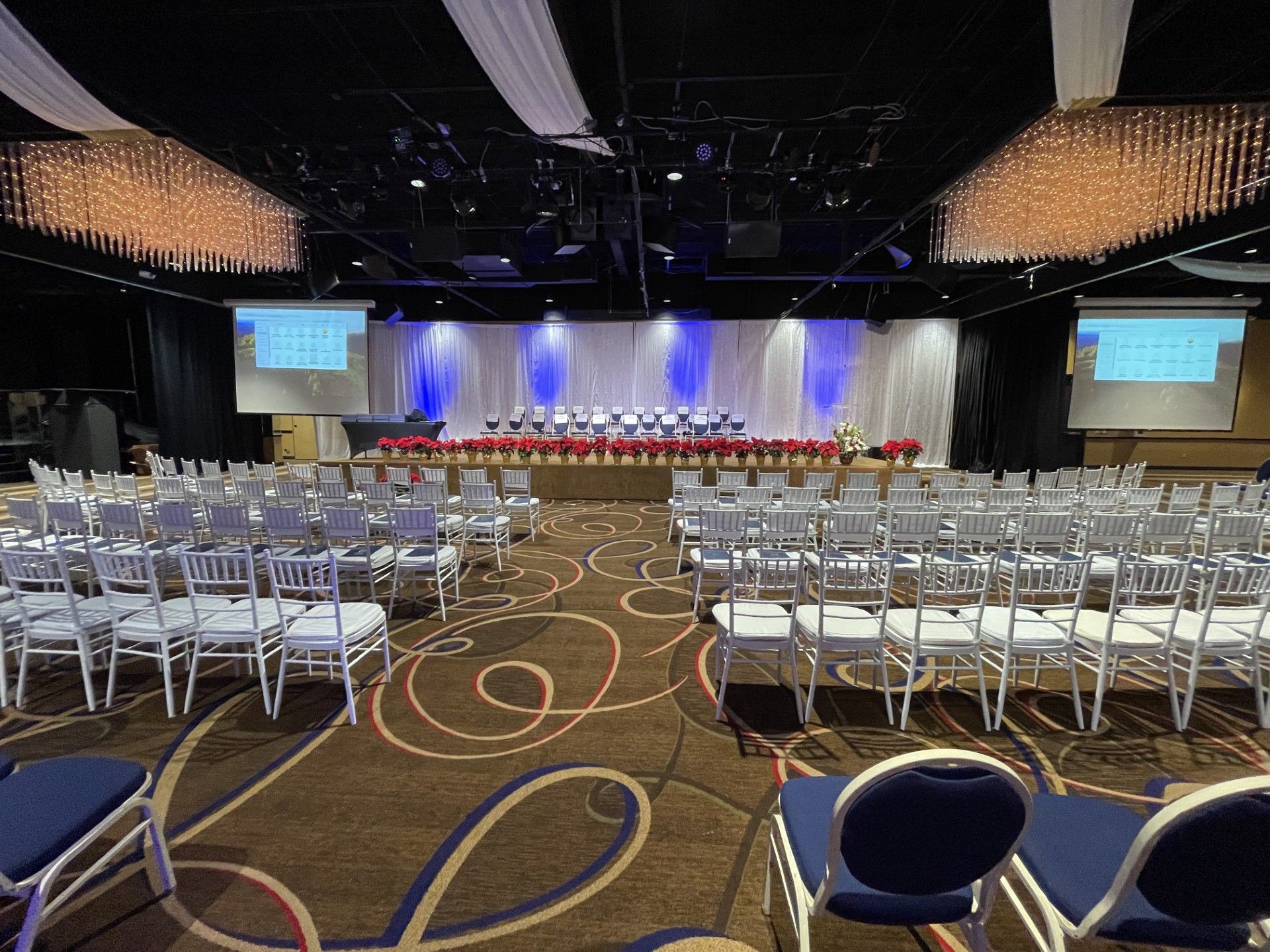 A large room with rows of chairs and a stage.