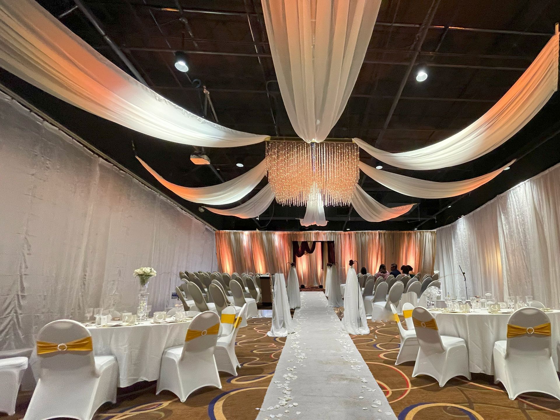 A large room with tables and chairs set up for a wedding.