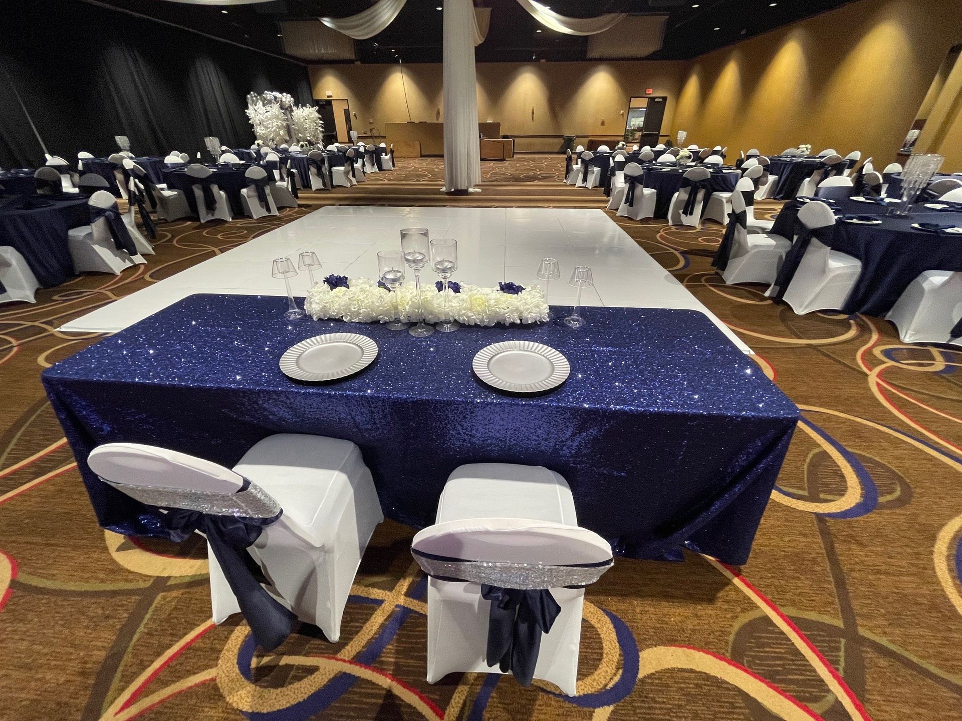 A large room with tables and chairs set up for a wedding reception.