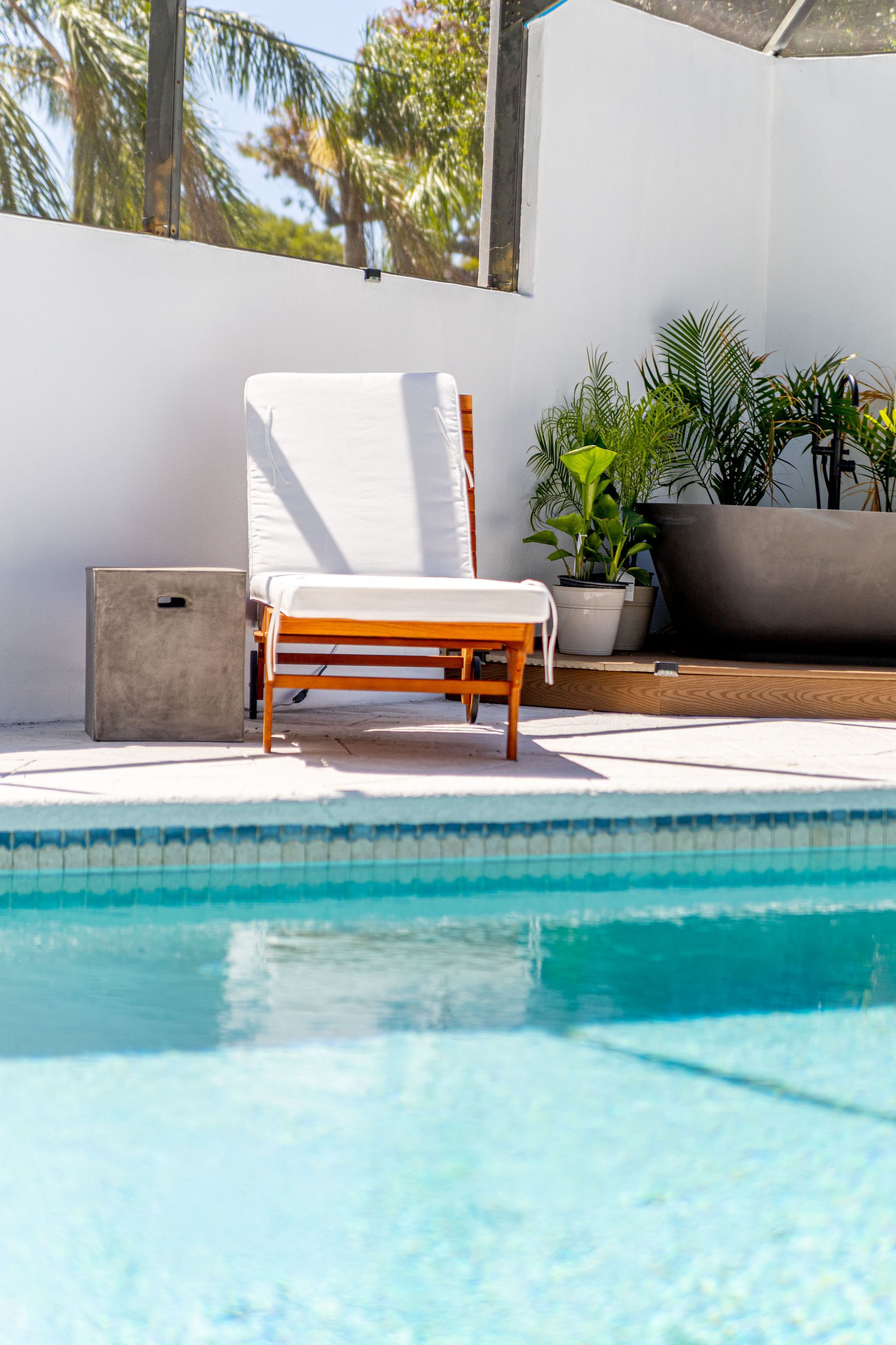 A chair is sitting next to a swimming pool.