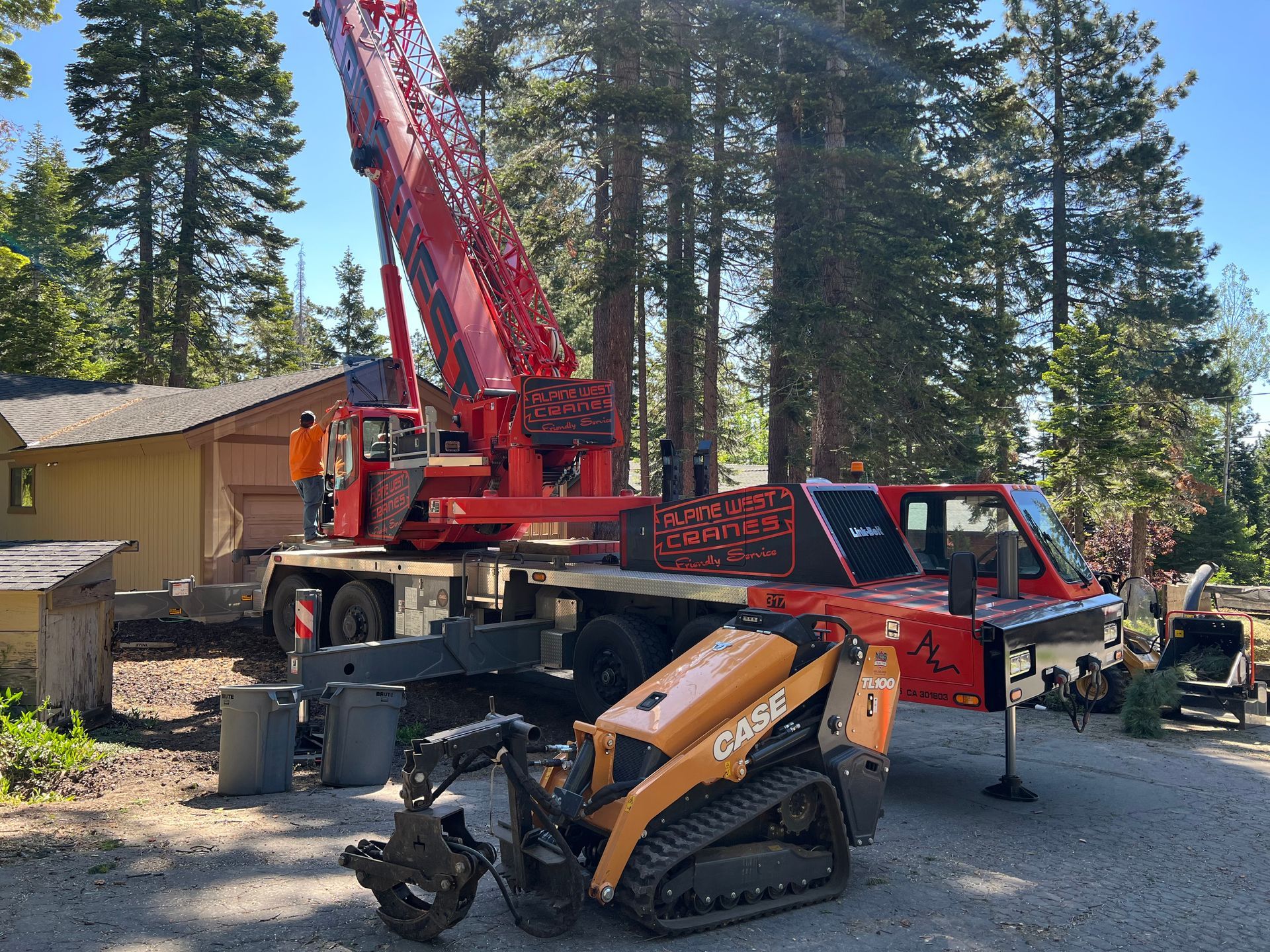A yellow crane is cutting a tree in a park.