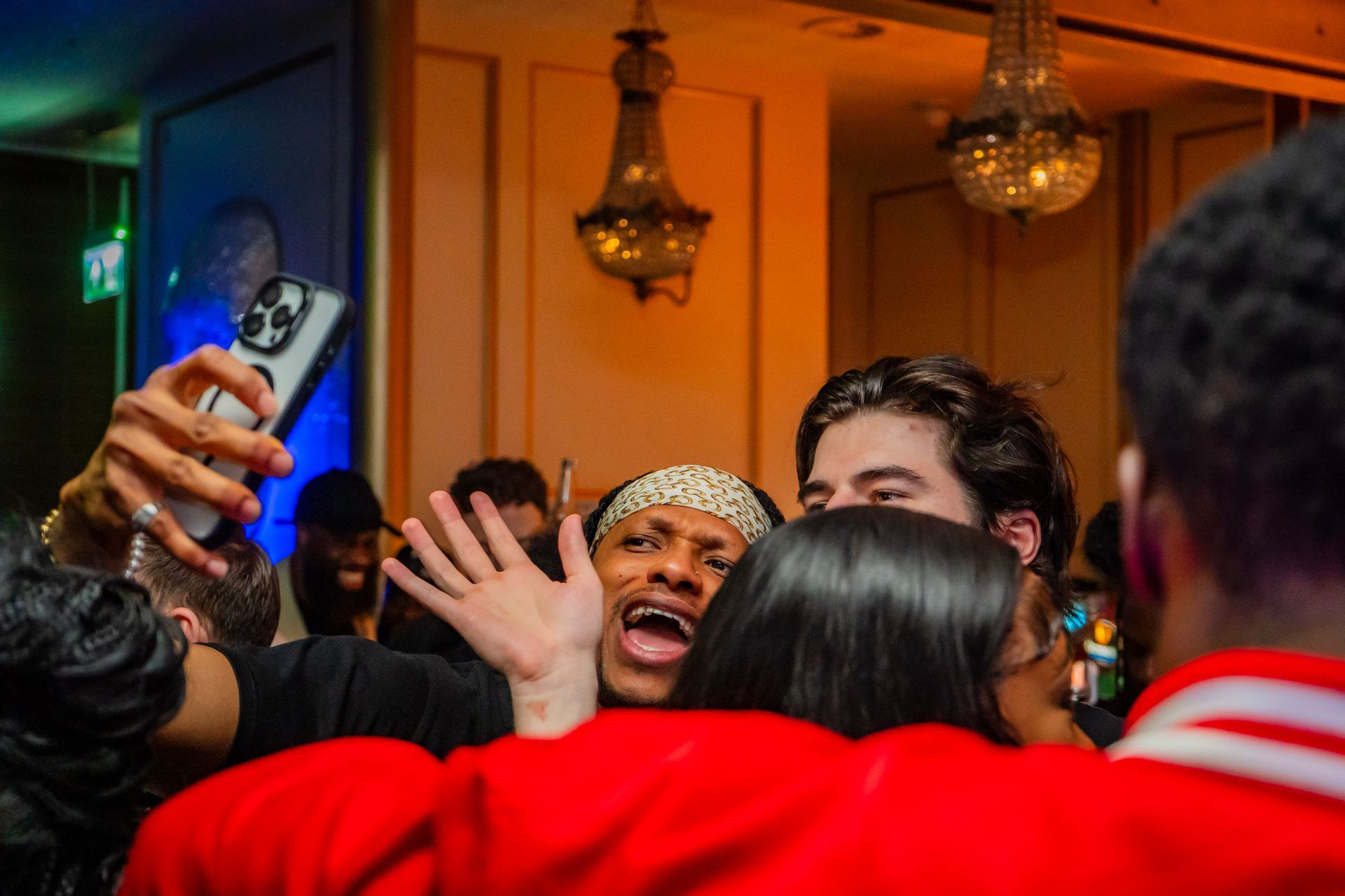 A group of people are taking a selfie in a room.