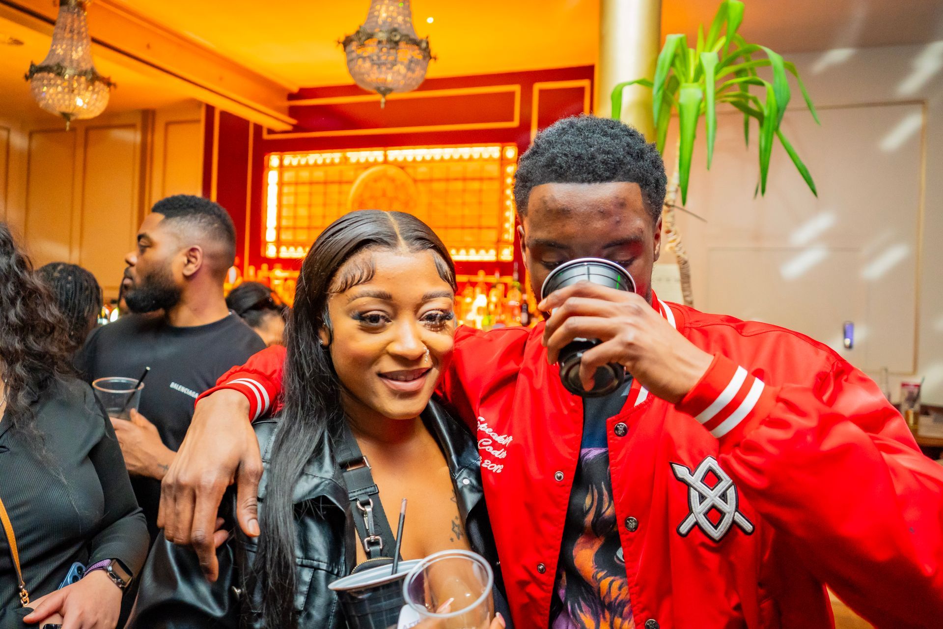 A man and a woman are standing next to each other at a party.