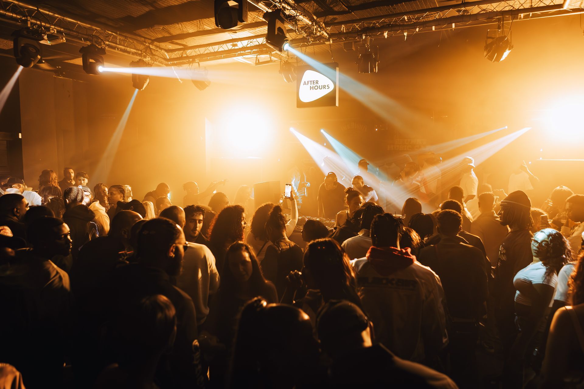 A large group of people are dancing in a club.
