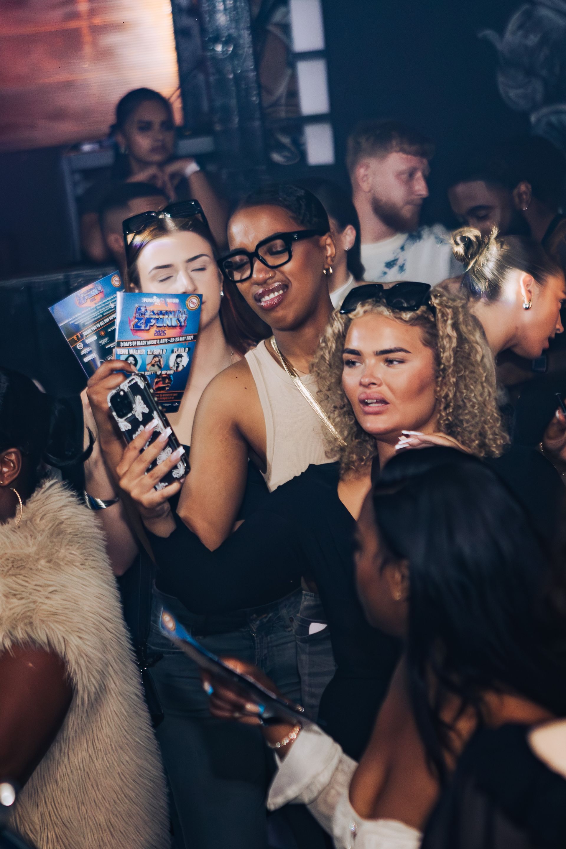 A group of people are standing in a crowd at a party.