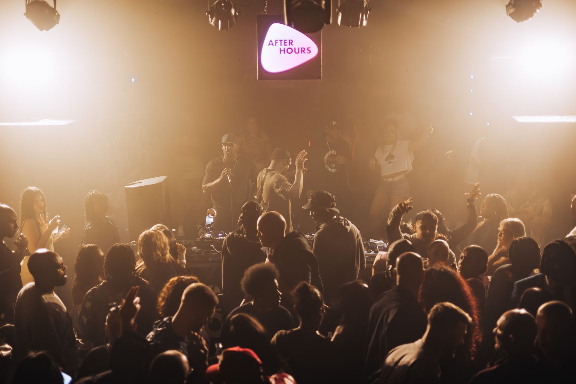 A crowd of people are sitting in a dark room at a concert.