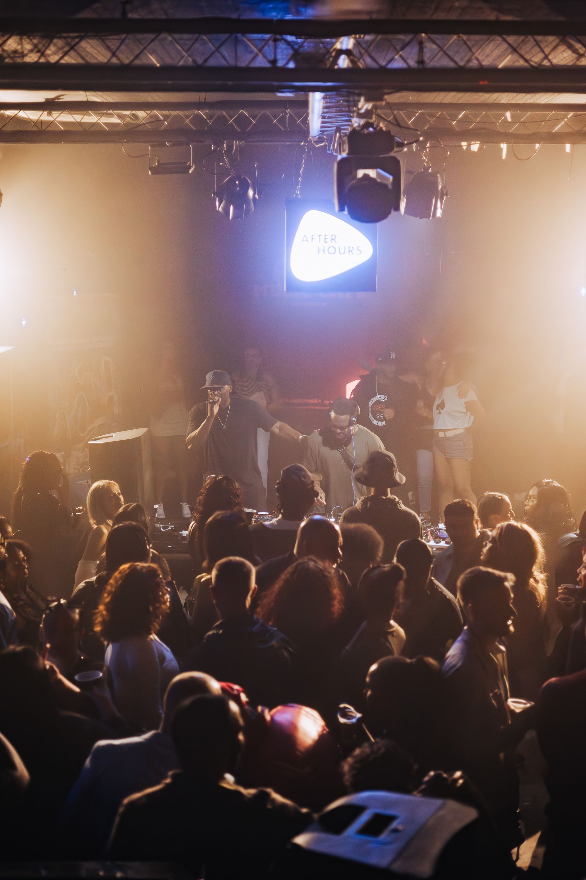 A crowd of people are sitting in a dark room at a concert.