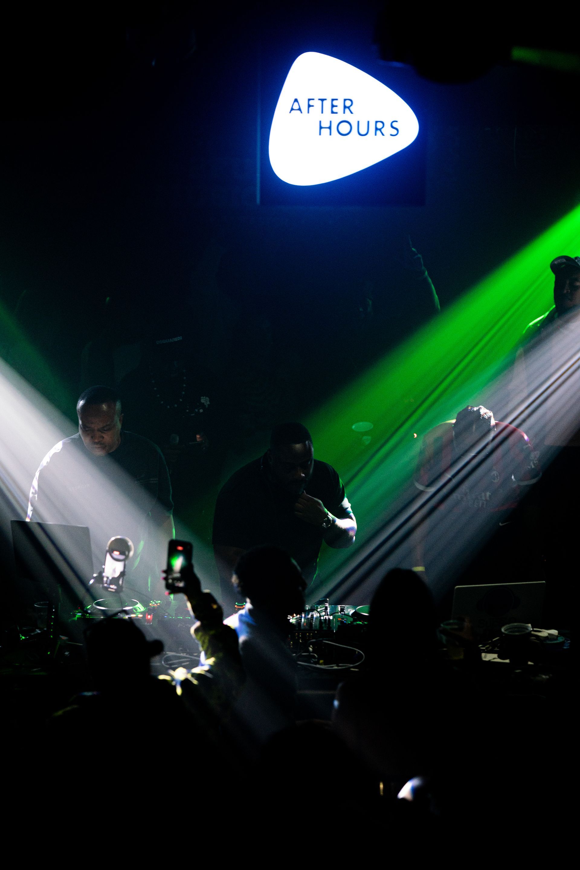 A sign that says after hours is lit up in a dark room