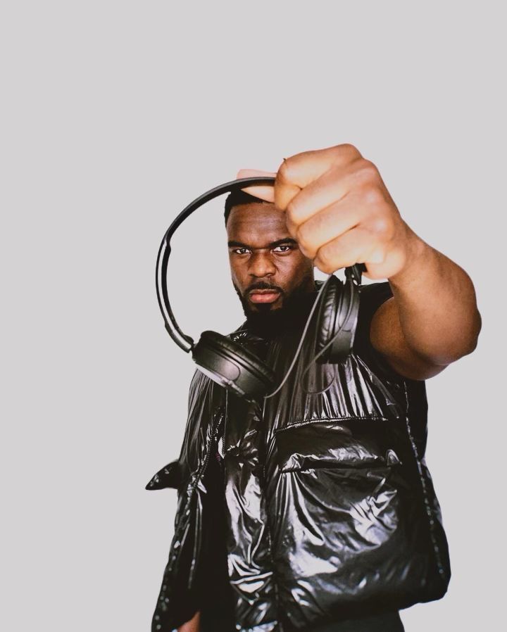 A man is holding a pair of headphones in his hand