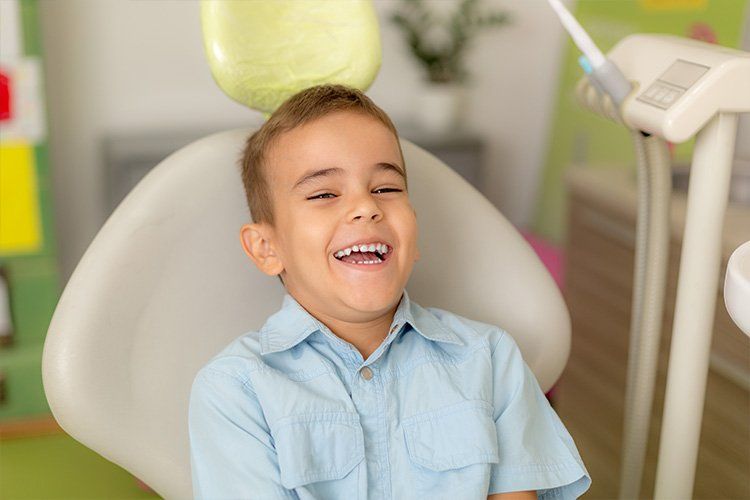 Child smiling in dental chair - Dental Studio 4 Kids