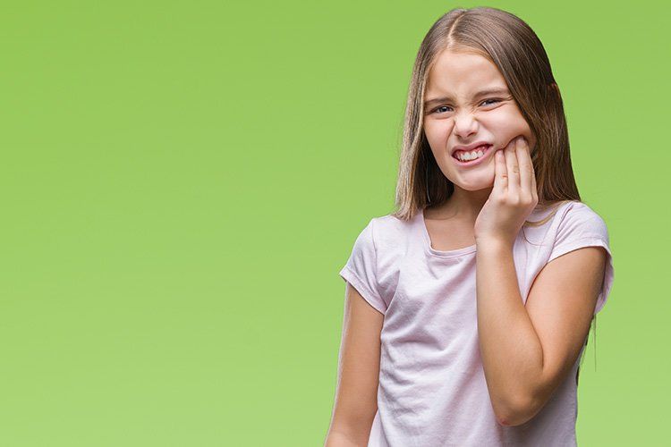Young girl wincing in pain - Dental Studio 4 Kids Lutz Florida