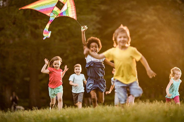 Group of kids running and flying Kites - Dental Studio 4 Kids Lutz Florida