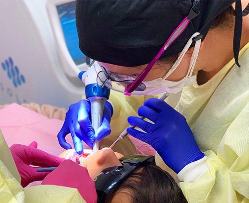 Dentist performing dental work on child Dental Studio 4 Kids Lutz Florida