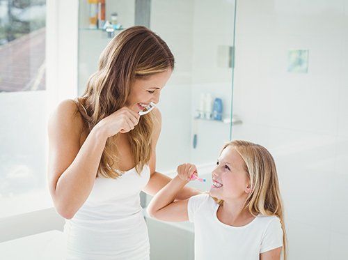 mom and daughter brushing teeth