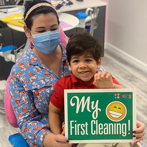 A woman and a child are holding a sign that says `` my first cleaning ''.
