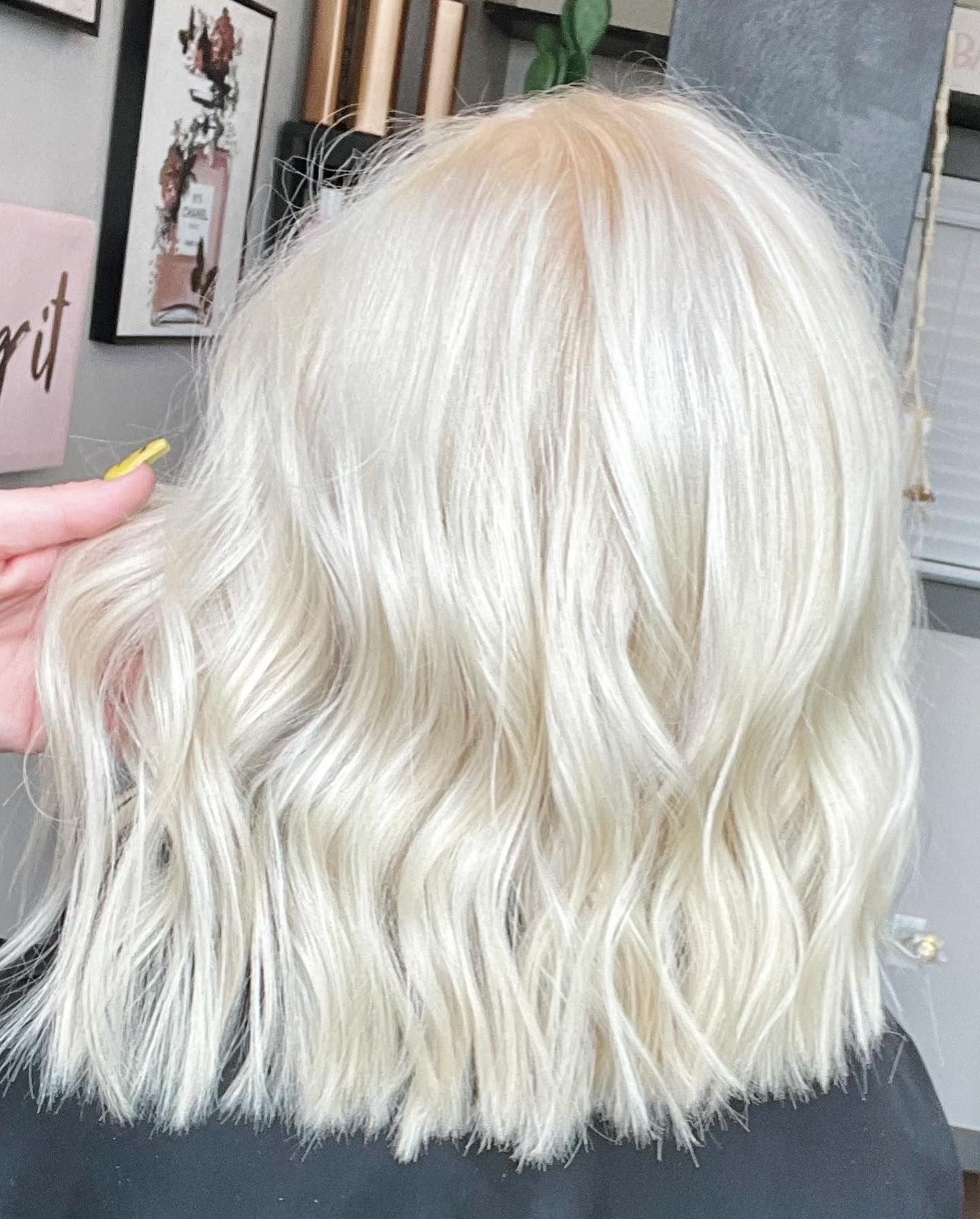 Wavy, platinum blonde bob hairstyle, in a salon setting.