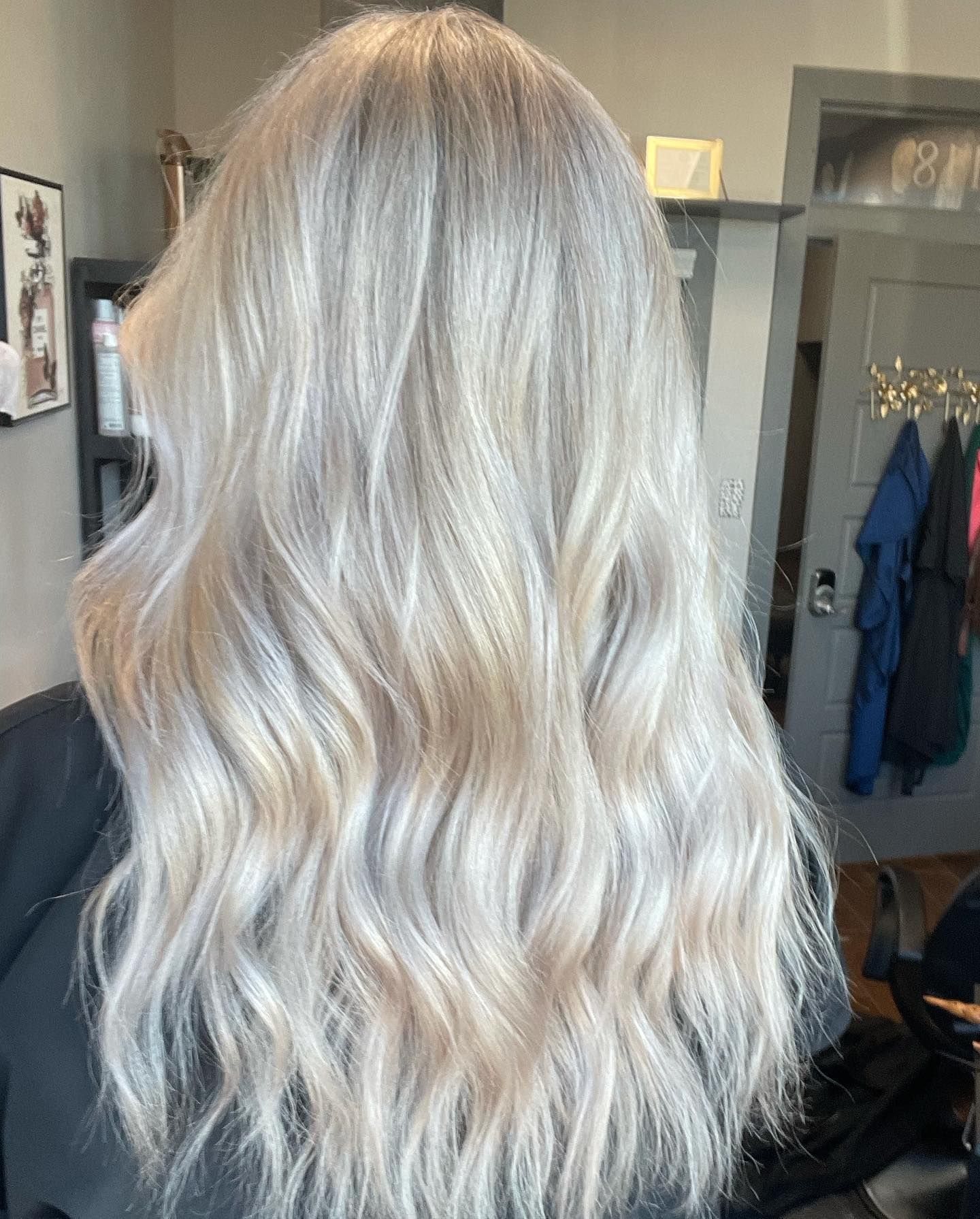 Wavy, platinum blonde hair styled with a slight wave, in a hair salon.