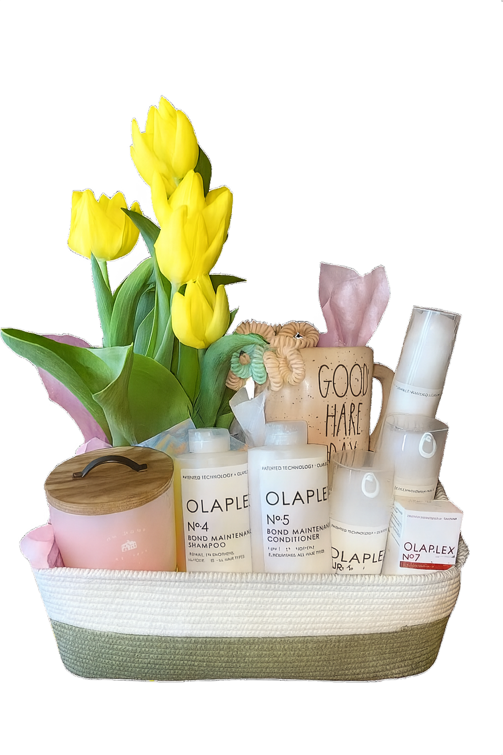 Basket with yellow tulips, skincare products, candle, and mug, likely a gift.