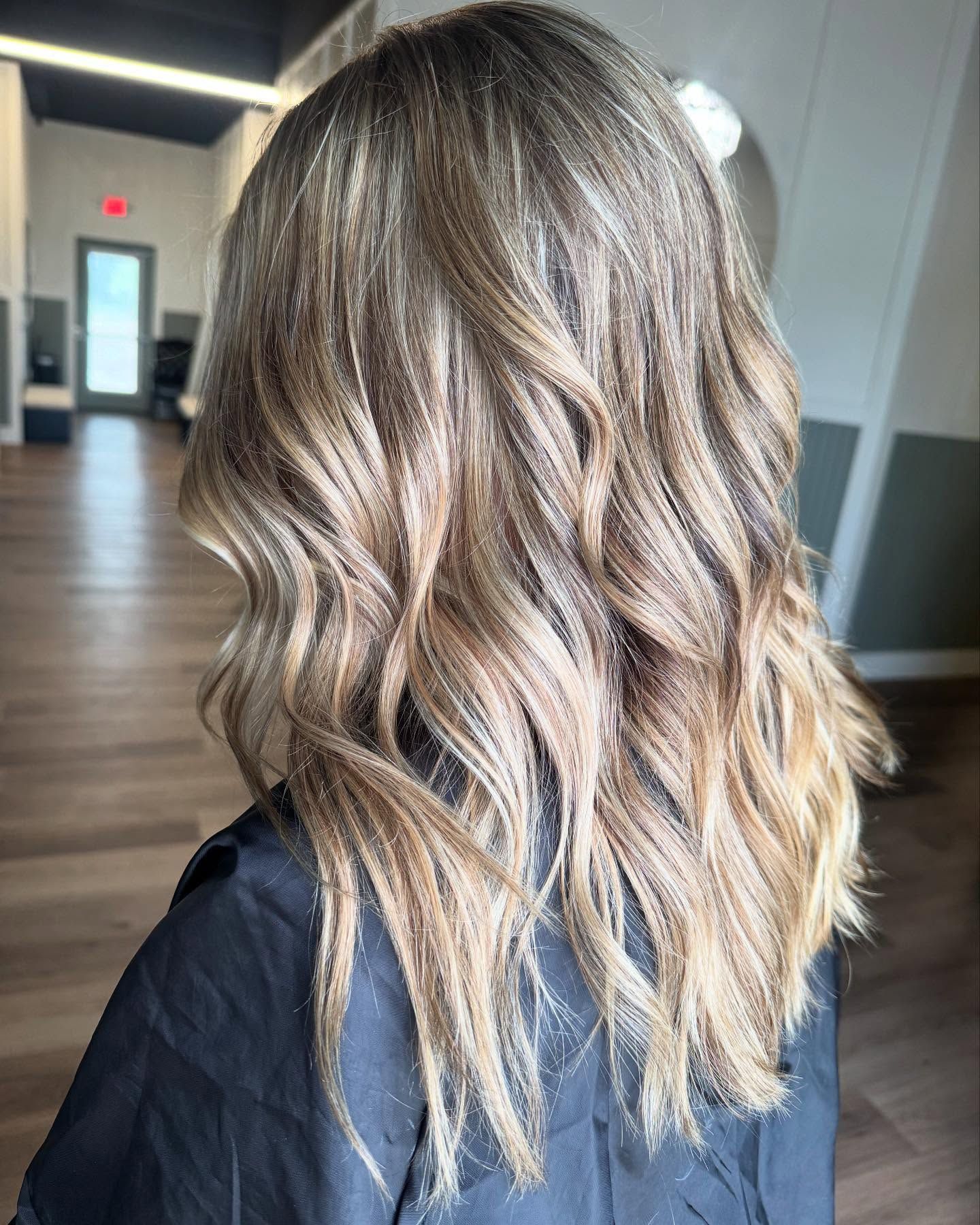 Woman with wavy, layered blonde and brown balayage hair.