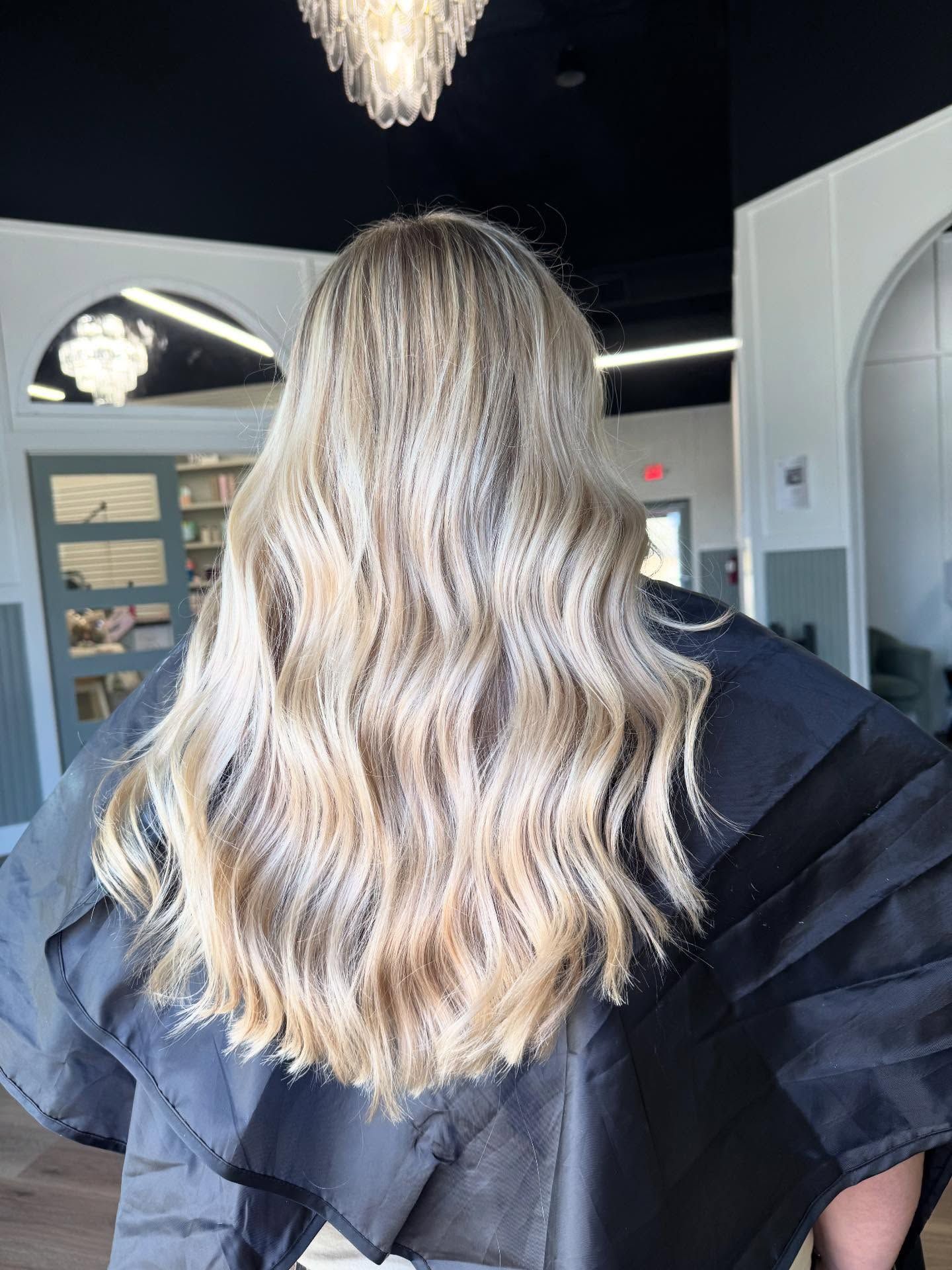 Long, wavy blonde hair styled after a salon visit.